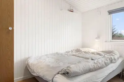 a bed in a white room with a window at 741-Thisted-Klemsvej-29 in Nørre Vorupør