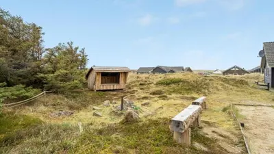 a wooden bench sitting on top of a hill at Villavilla 176 - Vrist, Vestjylland in Harboør