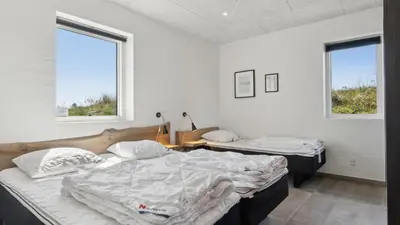 two beds in a room with two windows at Villavilla 607 - Vorupør, Nordjylland in Thisted