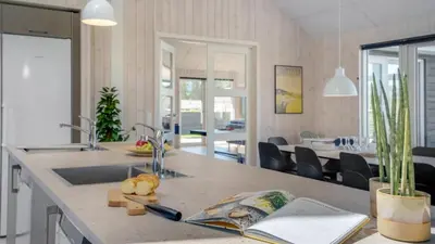 a kitchen with a sink and a dining room at Villavilla 542 - Hostrup Strand, Limfjorden in Spottrup