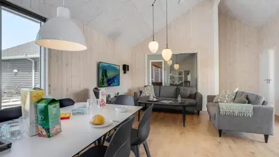 a kitchen and living room with a table and chairs at Villavilla 542 - Hostrup Strand, Limfjorden in Spottrup