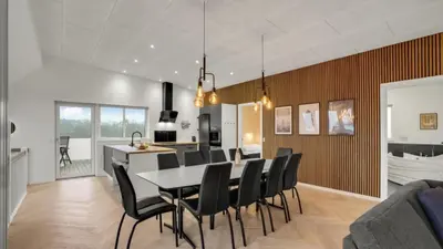 a dining room and kitchen with a table and chairs at Villavilla 603 - Hostrup Strand, Limfjorden in Spottrup