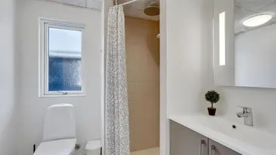 a white bathroom with a shower and a sink at Villavilla 547 - Hostrup Strand, Limfjorden in Spottrup