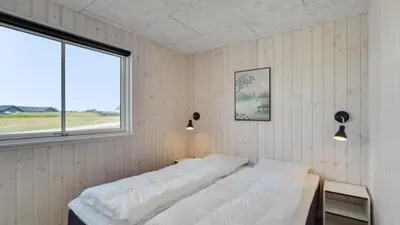 a bedroom with a bed and a window at Villavilla 547 - Hostrup Strand, Limfjorden in Spottrup