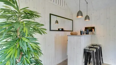 a palm tree in a room with a counter and stools at Villavilla 547 - Hostrup Strand, Limfjorden in Spottrup