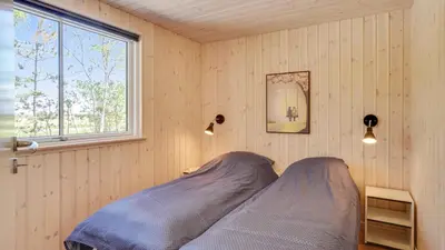 a bed in a corner of a room with a window at Villavilla 494 - Thorup Strand, Nordjylland in Fjerritslev