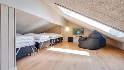 a room with a bunch of beds in a attic at Villavilla 494 - Thorup Strand, Nordjylland in Fjerritslev