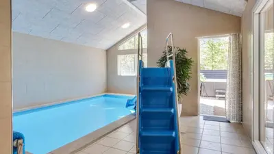 a large swimming pool with a blue slide in a room at Villavilla 494 - Thorup Strand, Nordjylland in Fjerritslev