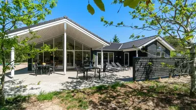 a house with glass doors and a patio at Villavilla 494 - Thorup Strand, Nordjylland in Fjerritslev