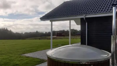 a hot tub sitting on the side of a house at Villavilla 539 - Hostrup Strand, Limfjorden in Spottrup