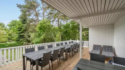 a patio with a table and chairs on a deck at Villavilla 373 - Glyngøre, Limfjorden in Roslev