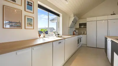 a kitchen with white cabinets and a large window at Villavilla 476 - Vorupør, Nordjylland in Thisted