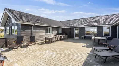a patio with chairs and tables and a house at Villavilla 476 - Vorupør, Nordjylland in Thisted