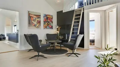 a living room with two chairs and a table and a ladder at Villavilla 476 - Vorupør, Nordjylland in Thisted