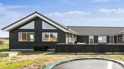 a black house with a swimming pool in front of it at Villavilla 476 - Vorupør, Nordjylland in Thisted