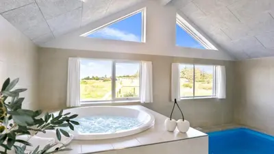 a bathroom with a large tub in a room with windows at Villavilla 476 - Vorupør, Nordjylland in Thisted