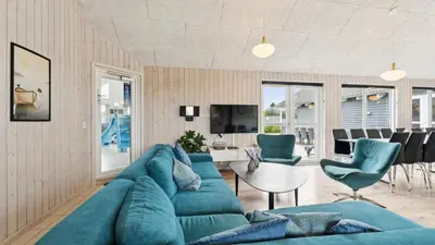 a living room with a blue couch and chairs at Villavilla 404 - Hostrup Strand, Limfjorden in Spottrup