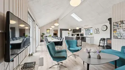a living room with blue chairs and a table at Villavilla 404 - Hostrup Strand, Limfjorden in Spottrup