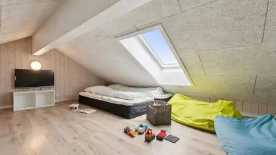 a attic bedroom with a bed and a skylight at Villavilla 404 - Hostrup Strand, Limfjorden in Spottrup
