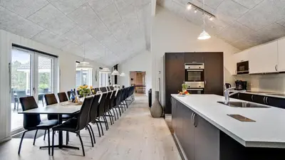 a kitchen and dining room with a table and chairs at Villavilla 431 - Hostrup Strand, Limfjorden in Spottrup