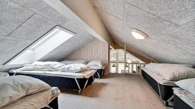 a attic room with three beds and a window at Villavilla 431 - Hostrup Strand, Limfjorden in Spottrup