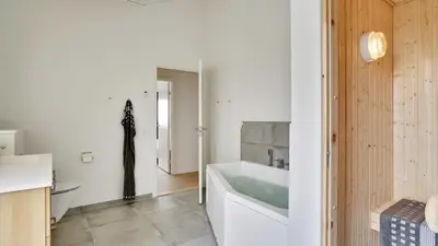 a white bathroom with a tub and a sink at Villavilla 514 - Grønhøj, Nordjylland in Løkken