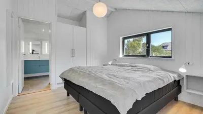 a bedroom with a large bed and a window at Villavilla 909 - Blokhus, Nordjylland in Blokhus