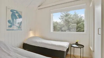 a bedroom with a bed and a window at Villavilla 411 - Blokhus, Nordjylland in Blokhus