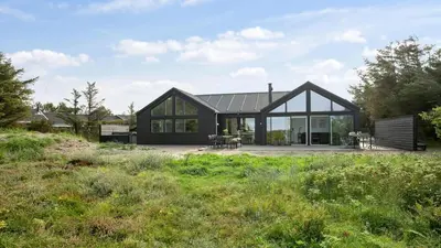 a house with a black roof at Villavilla 411 - Blokhus, Nordjylland in Blokhus