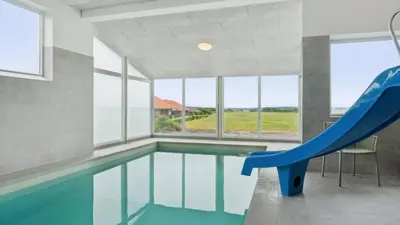 an indoor swimming pool with a slide and an escalator at Villavilla 645 - Hostrup Strand, Limfjorden in Spottrup
