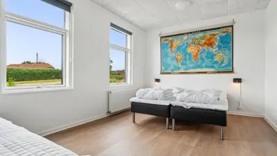 a bedroom with a bed and a map on the wall at Villavilla 645 - Hostrup Strand, Limfjorden in Spottrup