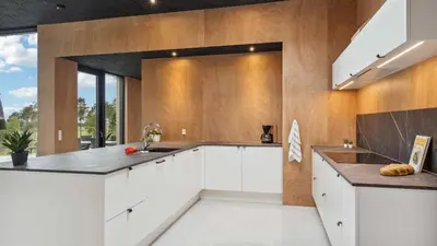 a kitchen with white cabinets and wooden walls at Villavilla 684 - Virksund, Limfjorden in Højslev