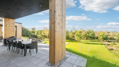 a dining area with a table and chairs on a patio at Villavilla 684 - Virksund, Limfjorden in Højslev