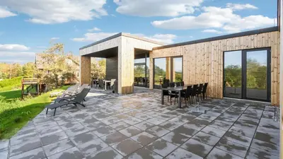 a patio with chairs and a table and some windows at Villavilla 684 - Virksund, Limfjorden in Højslev