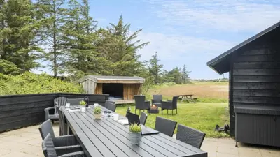 a wooden table and chairs on a patio at Villavilla 637 - Vorupør, Nordjylland in Snedsted