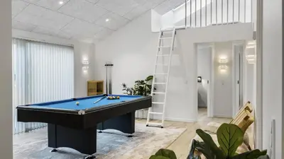 a pool table in a living room with a ladder at Villavilla 683 - Blokhus, Nordjylland in Saltum