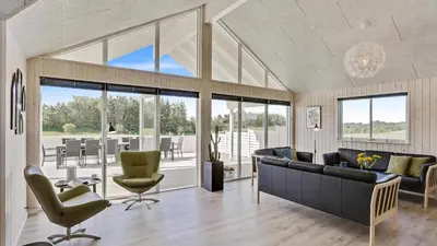 a living room with a black couch and chairs at Villavilla 405 - Hostrup Strand, Limfjorden in Spottrup