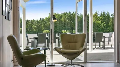 a room with chairs and a table on a balcony at Villavilla 405 - Hostrup Strand, Limfjorden in Spottrup