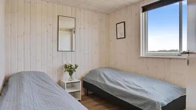 a bedroom with two twin beds and a window at Villavilla 405 - Hostrup Strand, Limfjorden in Spottrup