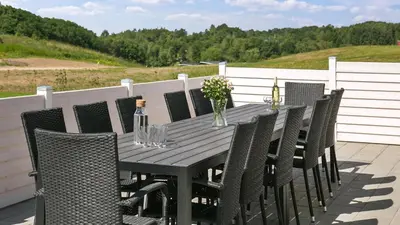 a black table with chairs and bottles of wine at Villavilla 405 - Hostrup Strand, Limfjorden in Spottrup