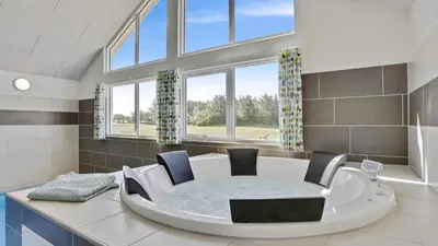 a bathroom with a tub with two chairs in it at Villavilla 405 - Hostrup Strand, Limfjorden in Spottrup