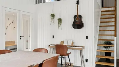 a dining room with a table and a guitar on the wall at Villavilla 686 - Hostrup Strand, Limfjorden in Spottrup