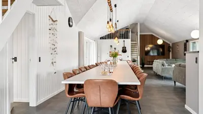 a dining room with a long table and chairs at Villavilla 686 - Hostrup Strand, Limfjorden in Spottrup