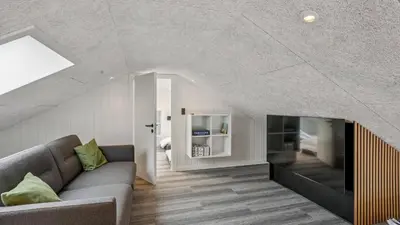 an attic living room with a couch and a bed at Villavilla 686 - Hostrup Strand, Limfjorden in Spottrup