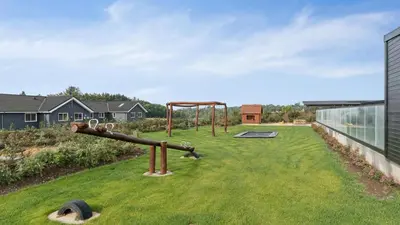 an empty playground in a grassy yard on a building at Villavilla 686 - Hostrup Strand, Limfjorden in Spottrup