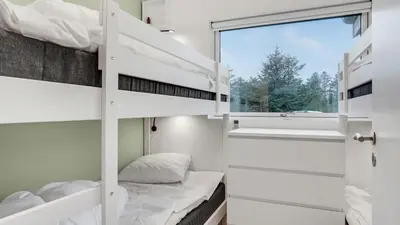 a bedroom with bunk beds and a window at Villavilla 692 - Blokhus, Nordjylland in Blokhus