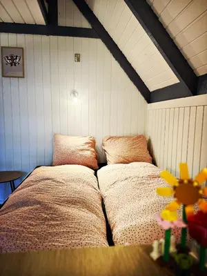 a bedroom with two beds in the corner of a room at Bovbjerg Camping in Lemvig