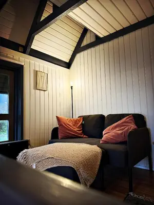 a living room with a couch in the corner of a room at Bovbjerg Camping in Lemvig