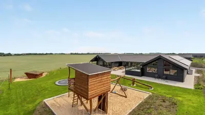 an aerial view of a house with a playground at Villavilla 546 - Hostrup Strand, Limfjorden in Spottrup