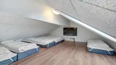 a room with two beds and a tv in a attic at Villavilla 546 - Hostrup Strand, Limfjorden in Spottrup